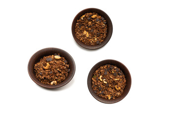 Chocolate granola cereal with nuts in a bowl background.