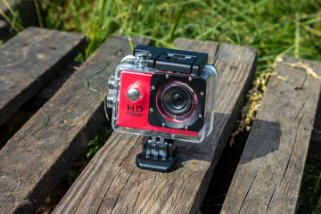 Action camera in a protective box on a wooden background.