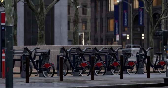 Row of Green bicycles for rent. Electric bicycle charging station. Shared electric bikes parked on city street early in the morning