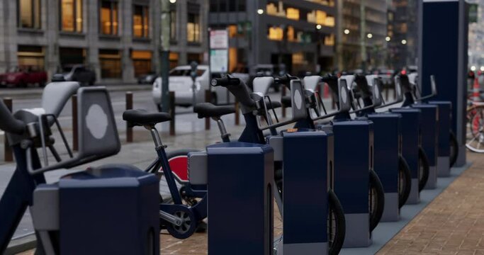 Row of Green bicycles for rent. Electric bicycle charging station. Shared electric bikes parked on city street early in the morning