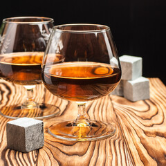Glass with whiskey on a wooden table and black background. Mockup template. 
