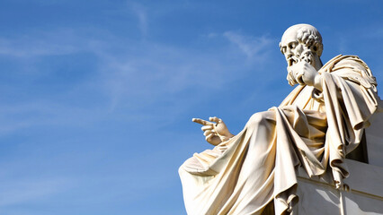 Fototapeta premium Famous Greek philosopher - Aristotle stone statue against the blue sky with space to write your text