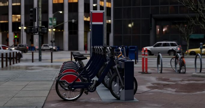 Row of Green bicycles for rent. Electric bicycle charging station. Shared electric bikes parked on city street early in the morning