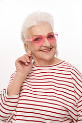 Beautiful senior woman in sunglasses posing in studio