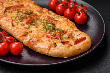 Delicious oven fresh flatbread pizza with cheese, tomatoes, sausage, salt and spices