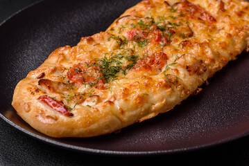 Delicious oven fresh flatbread pizza with cheese, tomatoes, sausage, salt and spices