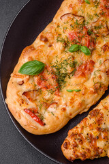 Delicious oven fresh flatbread pizza with cheese, tomatoes, sausage, salt and spices