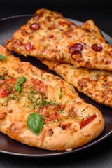 Delicious oven fresh flatbread pizza with cheese, tomatoes, sausage, salt and spices
