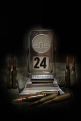 Bullets, vintage calendar and Ukrainian flag on camouflage background in darkness