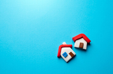 Houses on a blue background. Place for text. Find most suitable housing options. Offers on real estate market. Realtor services. Buying and selling. Mortgage. Valuation of residential buildings.