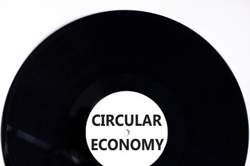 Circular economy symbol. Concept words Circular economy on beautiful black vynil disk. Beautiful white table white background. Business circular economy concept. Copy space.