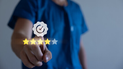 Quality control. Businessman hand checking mark four star rating on checklist box with pen to...