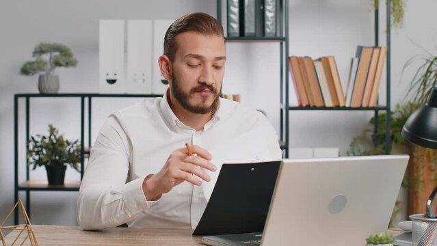 Business man reading business contract, planning project, analyzing resume, shakes finger, saying No, unsatisfied disagree, candidate with failure at office looking at camera talking, online interview