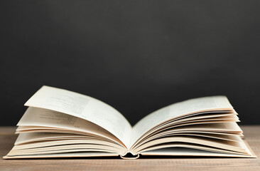 open book on table against black chalkboard background