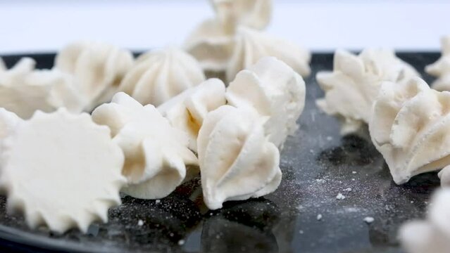 Zefir falling close up. White pieces of marshmallow fall in slow motion a black background and bounce off each other. Closeup. . High quality FullHD footage