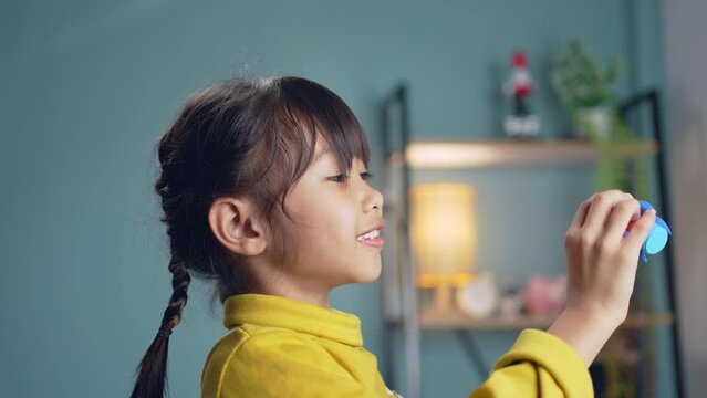 Little girl playing with toy space rocket in the living room.