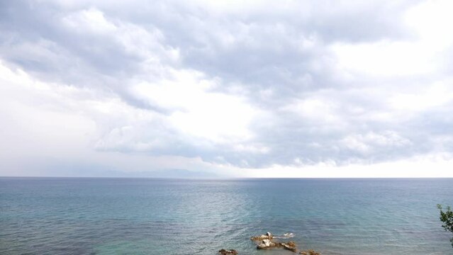 View of sea waves and rocky coast with cloudy sky, Greece, Peloponnese.