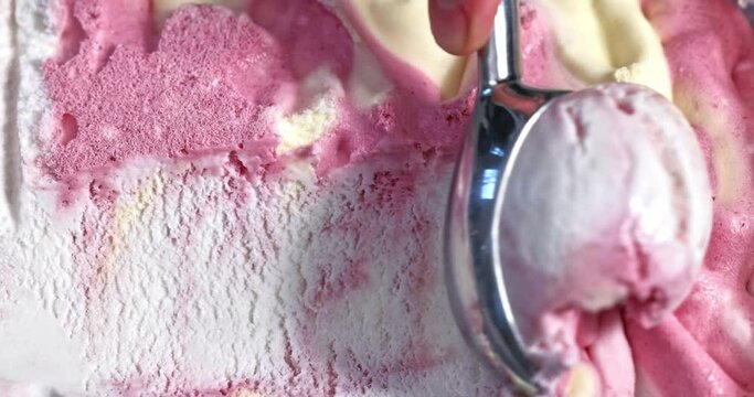 cranberry, mascarpone and vanilla ice cream scooping out of container by metal spoon