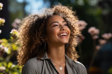 Portrait of happy young black woman laughing against blue wall