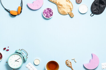Insomnia concept. Alarm clock, sleeping mask, herbal tea, aromatic salt and natural pills on light blue background top view. 