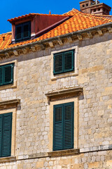 street view of the old town of Dubrovnik in Croatia, medieval European architecture, city streets, windows with wooden shutters, red tiled roofs, the concept of traveling in the Balkans