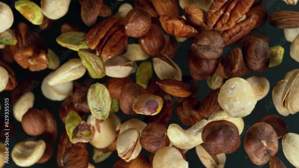 Poster super slow motion of rotating mix nuts up to the air. filmed on high speed cinema camera, 1000fps, p