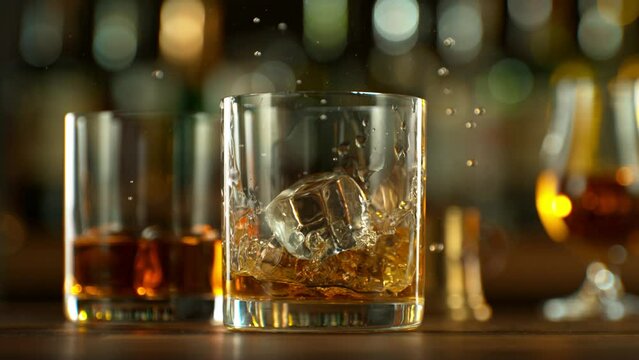 Super Slow Motion of Falling Ice Cube Into Whiskey Drink. Filmed on High Speed Cinema Camera, 1000 fps. Speed Ramp Effect.