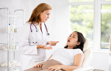 Obraz premium Doctor discussing asian woman about anti-aging beauty procedures in medical office