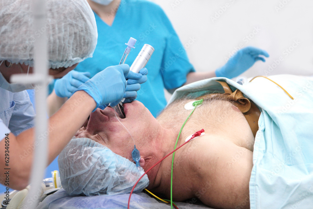 Wall mural Tracheal intubation. An elderly man before surgery. Preparation for anesthesia.Introduction of breathing tube. Modern medicine.