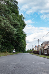Droga ciągnąca się przez osiedle o letniej porze w obszarach podmiejskich zachodniej Polski	

