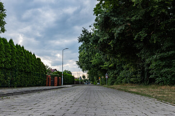 Droga ciągnąca się przez osiedle o letniej porze w obszarach podmiejskich zachodniej Polski	
 - obrazy, fototapety, plakaty