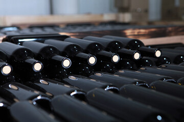 Large number of bottles of wine are stacked in storage boxes. Young white wine in bottles.Craft...