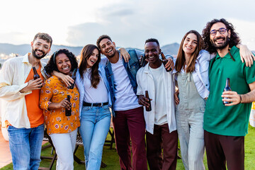 Group portrait of young diverse friends standing together at rooftop party. Friendship and youth...