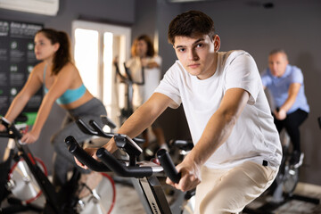 Fototapeta na wymiar Woman and man doing cardio workout out, training on exercise bike