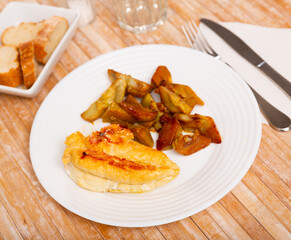 Portion of fried chicken breast served with artichokes