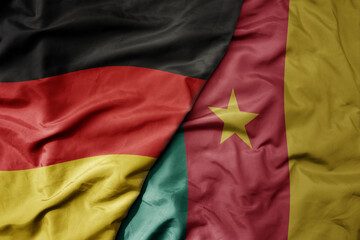 big waving realistic national colorful flag of germany and national flag of cameroon .