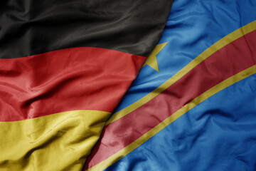 big waving realistic national colorful flag of germany and national flag of democratic republic of the congo .