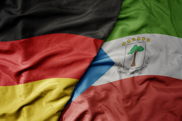big waving realistic national colorful flag of germany and national flag of equatorial guinea .