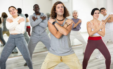 Happy caucasian man learning new modern dance in group dance lesson