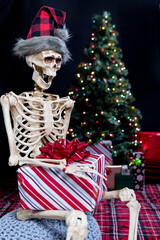 Skeleton excited on Christmas morning ready to open a present