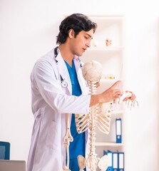 Young male doctor with skeleton