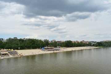 Obraz premium Novi Sad, Serbia - 07 30 2023: Štrand beach on Danube River shot from bridge on a cloudy day landscape