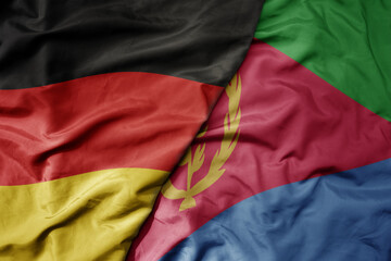 big waving realistic national colorful flag of germany and national flag of eritrea .