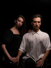 young couple white brunette man and white brunette woman with long hair on a dark background