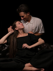 young couple white brunette man and white brunette woman with long hair on a dark background