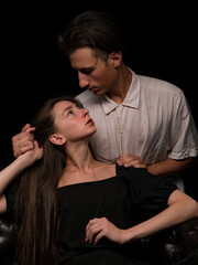 young couple white brunette man and white brunette woman with long hair on a dark background