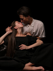 young couple white brunette man and white brunette woman with long hair on a dark background
