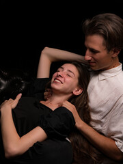 young couple white brunette man and white brunette woman with long hair on a dark background