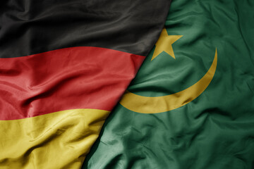 Obraz premium big waving realistic national colorful flag of germany and national flag of mauritania .
