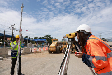 Female surveyor  examining the theodolite for inspecting on-site at work